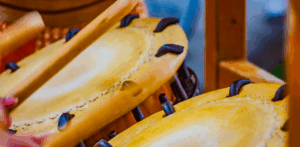 Close-up of traditional Japanese taiko drums being played with wooden sticks