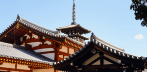 Traditional Japanese temple roof with ornate details and blue sky in the background