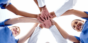 Medical team joins hands in unity, showing teamwork in healthcare