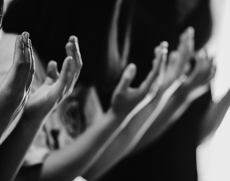 People praying with raised hands in spiritual worship