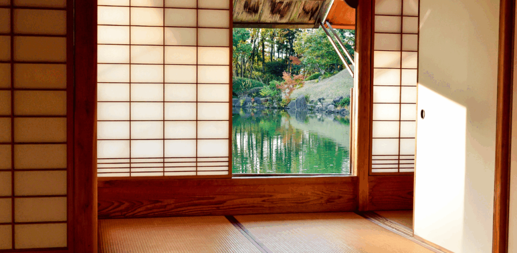 Serene view from inside a traditional Japanese room, looking out to a peaceful garden pond surrounded by greenery