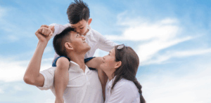 Smiling family bonding outdoors under blue sky